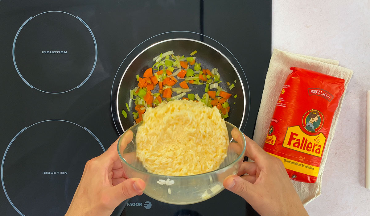 Batir huevos y mezlar con arroz en Arroz frito con huevos