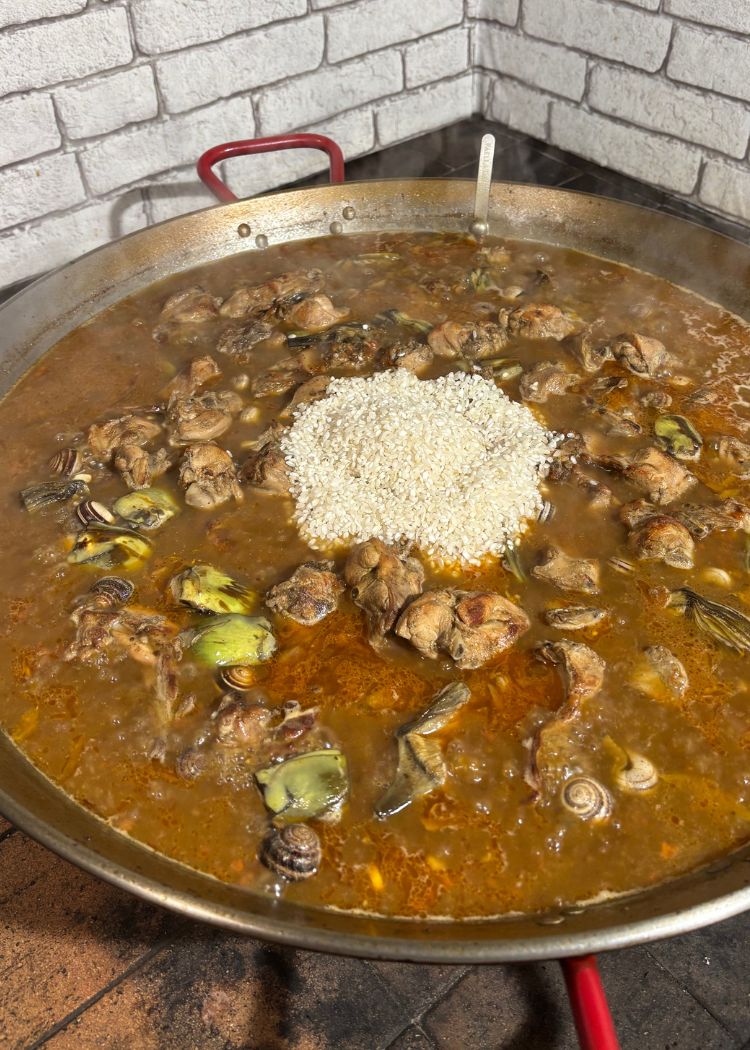 Incorporar el arroz en paella de conejo