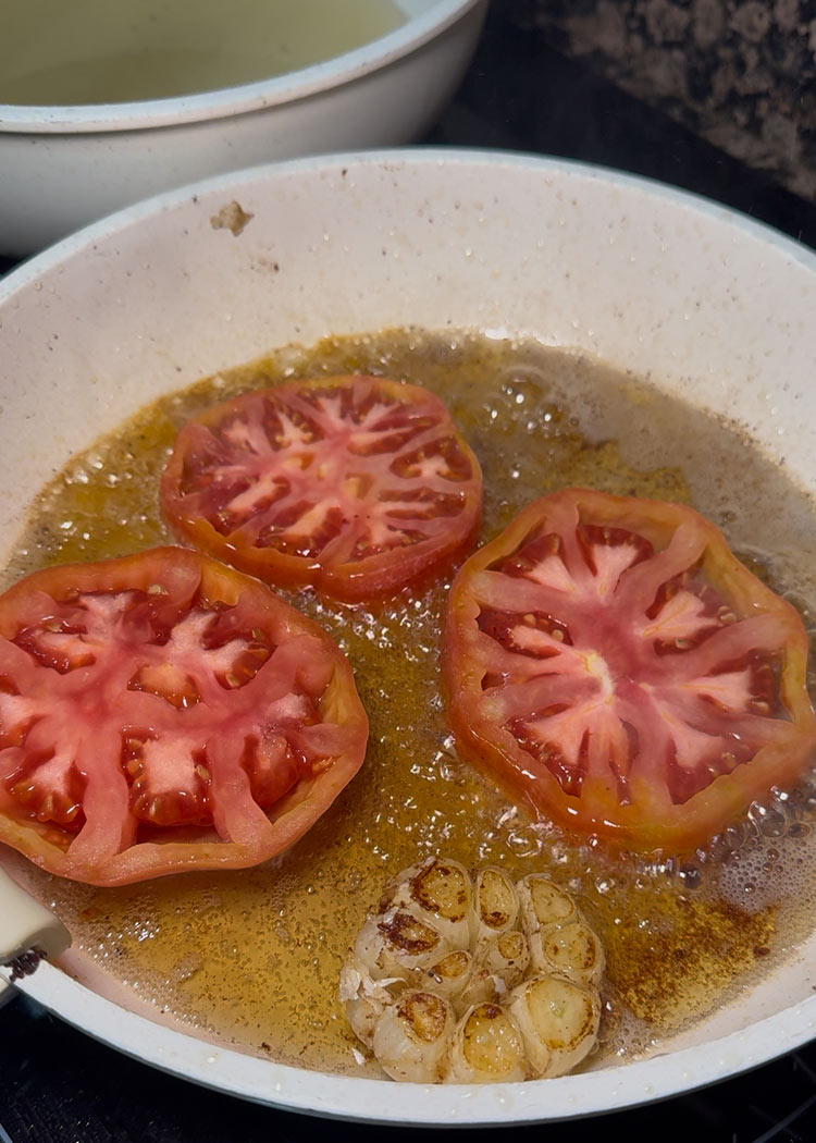 Sofreír rodajas de tomate en Arroz al horno con costillas